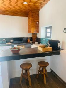 马尔旺Casa Pollard的厨房配有2张凳子和台面