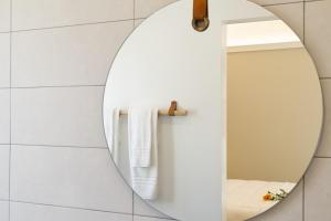 奥尔比亚La VIA Rooms and Terrace的浴室内有一面镜子,铺有白色瓷砖