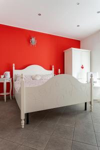 卡萨诺韦Malpensa Garden的卧室设有白色的床和红色的墙壁