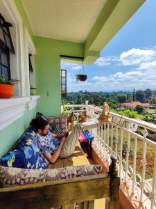 KangaruModern & Comfy Mt. Kenya Sunset View Apartment的躺在阳台上沙发上的人