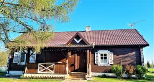 BereżyszczePodlaski Zakątek的一座带红色屋顶的小木房子