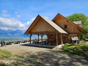 布莱德Koča na Taležu的湖畔的大型木制凉亭,配有桌椅