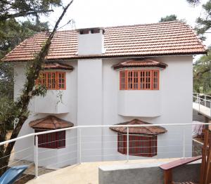 蒙特韦尔迪Pousada Vila Suiça - Monte Verde的白色房子,阳台上设有红色窗户