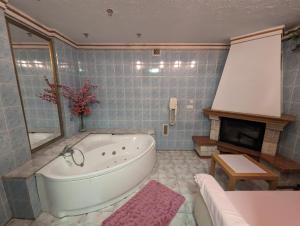 塔尔诺夫斯凯古雷Motel DRABEK的一间带大浴缸和壁炉的浴室