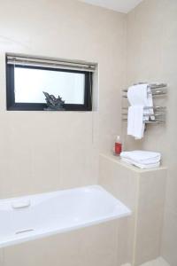 福克斯福德Luxury Three Bedroom Apartment Foxford County Mayo的浴室设有窗户、水槽和毛巾。