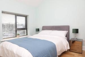 福克斯福德Luxury Three Bedroom Apartment Foxford County Mayo的一间卧室设有一张大床和一个窗户。