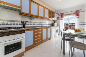 阿玛考德佩拉Sol & Mar的一间厨房,配有白色家电和桌椅