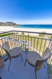 佩罗斯-吉雷克Logis Hôtel Ker Mor的阳台配有两把椅子,享有海滩美景