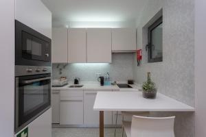 里斯本BeGuest Benfica Modern Flat的厨房配有白色橱柜和白色台面