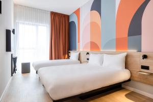 梅赫伦B&B HOTEL Mechelen的酒店客房设有两张床和窗户。