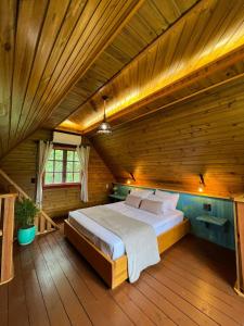 加里波第Locanda 65 - Serra Gaúcha的木制客房内的一间卧室配有一张大床