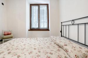 滕诺Appartamento nel cuore di Tenno的白色卧室配有一张带花卉床罩的床