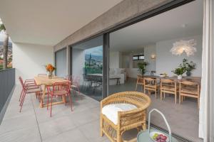 丰沙尔CASA DO MIRADOURO 5 by Heart of Funchal的一个带桌椅的阳台和一间用餐室