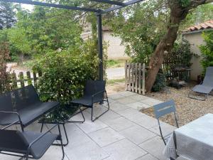 萨尔里昂Fanchon des Sablons的一个带椅子和桌子的庭院和一棵树