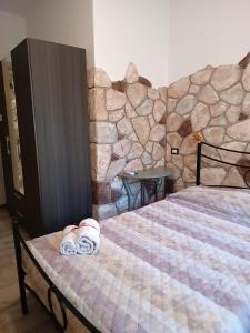阿尔盖罗Rocca Pinta Guest House的一间卧室配有带毛巾的床
