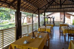 尼西亚弗洛雷斯塔Fazenda Bom Fim的餐厅设有黄色的桌椅和窗户。