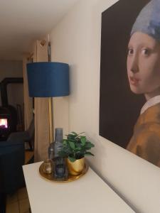 温特贝格Haus Annemiek的一张桌子,上面有台灯和一幅女人的画