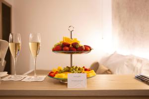 切法卢Meravigghia Suites Cefalù的桌上水果盘和两杯葡萄酒