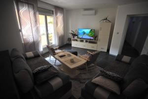 维舍格勒Apartman Nena Visegrad的带沙发、桌子和电视的客厅
