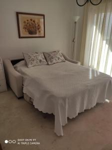 圣路易斯·德·萨比尼尔APARTAMENTO CASARES PLAYA的一间卧室配有一张带白色毯子的床和窗户。
