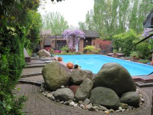 凯沃拉尔Ferienwohnung am Niederrhein的游泳池周围设有岩石的游泳池