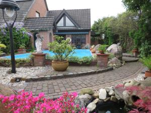 凯沃拉尔Ferienwohnung am Niederrhein的庭院中带游泳池的房子