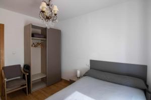 莱昂Apartamento paris的一间卧室配有一张床、一把椅子和一个吊灯。
