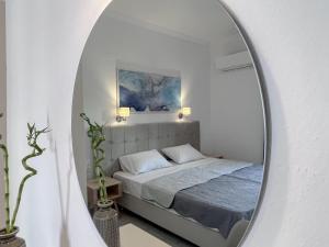 斯基亚索斯镇ATHANASIA APARTMENTS的一间卧室配有一张床和镜子