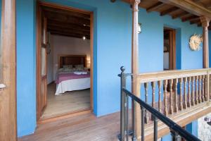 利亚内斯Madre Rosa I, casa rural con la playa a 12 km的一间拥有蓝色墙壁的卧室和一张位于客房内的床