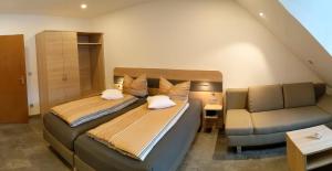 福恩施特劳斯祖姆施彻沃兹巴瑞酒店的一间带两张床和一张沙发的卧室