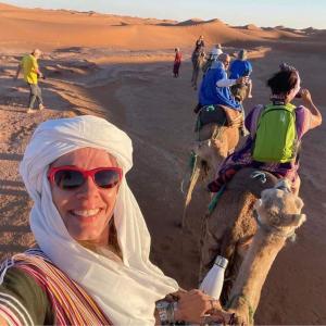 扎古拉berber sahara的一位在沙漠骑骆驼的女人