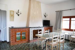 莫莱拉Villa Maria Beach Villa的客厅设有壁炉、桌子和椅子