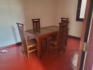 WatumullaMount lavinia home的一张木桌、两把椅子、一张桌子和一张桌子