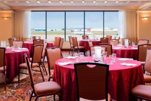 温莎洛克斯哈特福德布拉德利机场喜来登酒店的一间会议室,配有桌椅和红色桌布