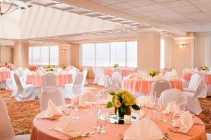 温莎洛克斯哈特福德布拉德利机场喜来登酒店的宴会厅配有白色的桌子和白色的椅子