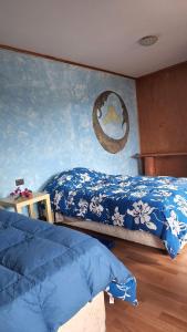 安加罗阿marari rapa nui的一间卧室设有两张床,墙上挂着一幅画