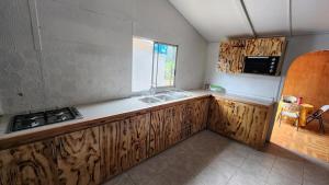 安加罗阿marari rapa nui的厨房配有木制橱柜和水槽。