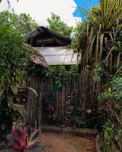 莱蒂西亚Casa do Xingú的一座带围栏和植物的木屋
