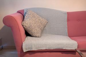 KhlóïNorma’s House的粉红色的沙发,上面有枕头
