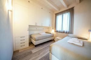 莫尼加La Giolosa Gardapartments的一间卧室设有两张床和窗户。