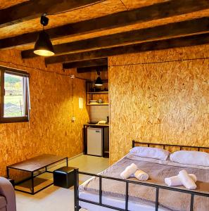 卡兹贝吉Kazbegi 5054的一间卧室设有一张床和木墙