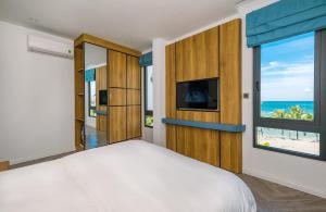 富国Cát Lợi Phú Quốc Hotel的一间卧室设有一张床,享有海景