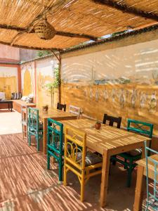 塔哈佐特Kasbari House的一间带木桌和椅子的用餐室