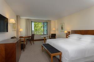 纽伦堡纽伦堡喜来登酒店的酒店客房带一张床、一张桌子和椅子