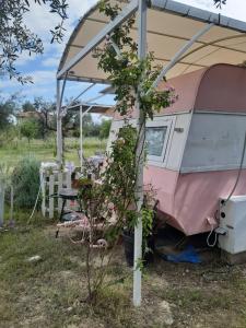 埃拉蒂尼Mary 's Retro Caravan的帐篷下一张桌子,上面有粉红色和白色的露营车