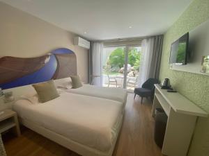 拉格朗德默特欧洲酒店的一间卧室配有一张床、一张书桌和一个窗户。