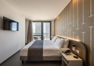利尼亚诺萨比亚多罗DIVA HOTEL LIGNANO - Adults Only的酒店客房,配有床和电视