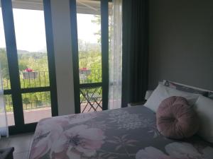 Cerro Lago MaggioreIL CILIEGIO DI ZOE的一间卧室设有一张床,享有阳台的景色