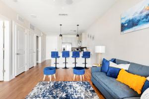 沃思堡Elegant & Luxurious Modern Apartment with Southern Charm的客厅配有蓝色的沙发和蓝色的凳子