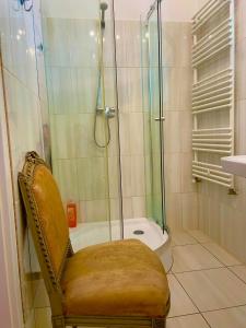 莫雄马扎尔古堡Villa Luca的带淋浴、椅子和浴缸的浴室